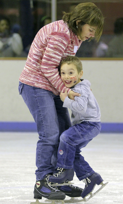Kim Carlton, a Kent State alumna, teaches her 4-year-old son Alex how to ice skate during Flash Ice Fest at the Ice Arena on Saturday. The free event featured ice skating, face painting and balloon animals. Kent State alumni were invited to bring friends and family to the event.. Photo by Anthony Vence
