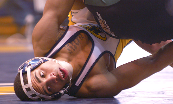 Junior Marcel Clopton architecture major wrestles his opponent from his back during Friday's meet against Eastern Michigan. Kent wins 30-3. Photo by Megan Galehouse.