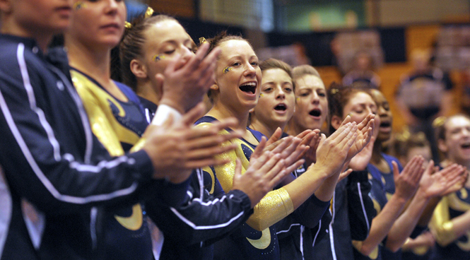 The Flashes congratulate Sophomore Lindsay Runyan after her performance on the balance beam Saturday at the M.A.C. Center. Runyan won on the uneven bars with a score of 9.825 and tied senior Christine Abou-Mitri and freshman Marie Case for second on the balance beam with a 9.725. The Flashes lost to Central Michigan 195.100-194.875. Photo by JESSICA YANESH.
