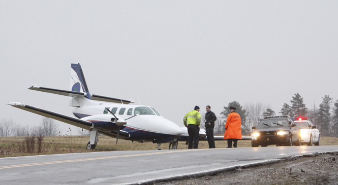 A commercial aircraft sits in a ditch on North River Road in Stow Tuesday. David Poluga, KSU airports operation coordinator, said the accident resulted in no injuries. A pilot and five passengers were inside the aircraft. Photos by Nikolas Kolenich