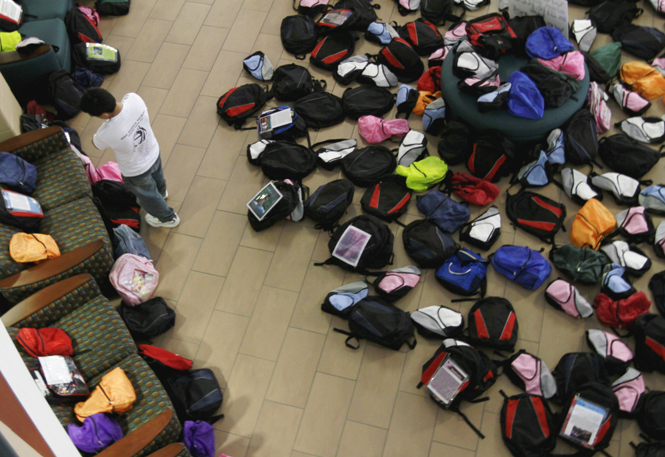 Sunny Timbalia, senior business management major, browses through backpacks at the Student Recreation and Wellness Center on Wednesday. There were 1,100 backpacks in total and 300 of them had individual stories about suicides. Photo by Lindsay Frumker.