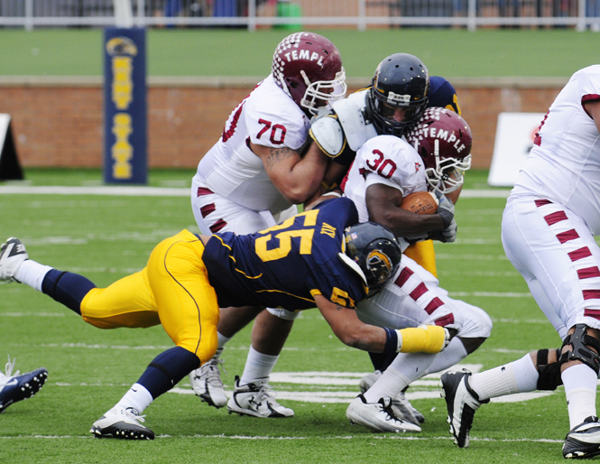 Freshman defensive lineman Roosevelt Nix and senior safety Brian Lainhart tackle a Temple offensive player. The Flashes lost to the Owls 28-10. Photo by Hannah Potes.