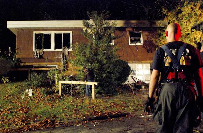 Kent fire fighter, Brock Murphy, surveyed the aftermath of a house fire on Columbus Street on Monday, Oct. 31. The home’s owner, Constance Mellott, former Kent State librarian, was rushed to Akron Children’s Hospital. Photo by Sam Verbulecz.