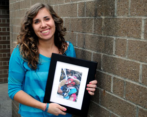 Olivia Sliman, junior electronic media production major, held a photo of the shoes she recently collected and donated for needy children in Jamaica on Sunday, Jan 8. Sliman began her collection last winter, and by spring she had 1,011 pairs of shoes to donate through Soles4Souls. Photo by Jenna Watson.