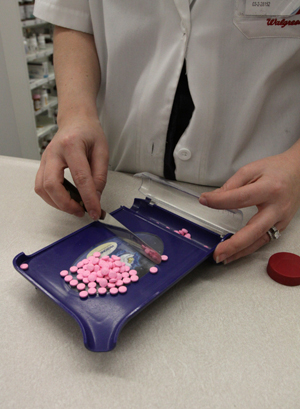 A pharmacist at a Kent Pharmacy fills out an orders of pills. Photo by Brian Smith.
