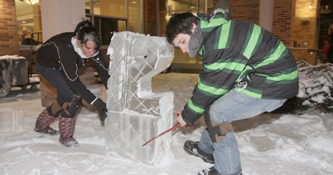 Caitlin English and Drew Chess, both senior hospitality management majors, move an ice sculpture during the VIP event Thursday at Eastway Center. Photo by Brian Smith