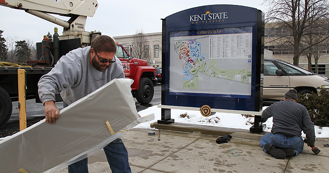 Workers replace a campus map between Franklin and Rockwell halls. The new maps feature LED lighting. Photo by Rachel Kilroy.