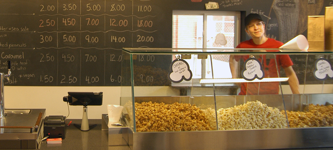 Popped! owner and operator Gwen Rosenberg waits for customers behind the counter of her new store in Acorn Alley. Popped! sells a variety of kettle corn, caramel corn and more, all made with local ingredients.