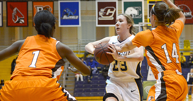 Kent State freshman guard Jamie Hutcheson, surrounded by the other team, looks to pass the ball in a game against Bowling Green at the M.A.C. Center Tuesday, February 28. The Flashes lost to the Falcons 91-48. Photo by Monica Maschak.