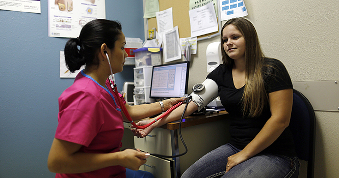 Cinthia Diaz, left, a family planning assistant with Planned Parenthood, takes a blood pressure reading from Tara Rogers of Wylie during a visit to the organization's Plano, Texas, facility Thursday, April 12, 2012. (G.J. McCarthy/Dallas Morning News/MCT).