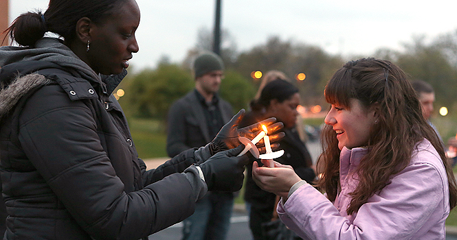 Lorriane Odhiambo lights Katelynn Dearths candle prior to the Take Back The Night march Thursday evening. Photo by Coty Giannelli.