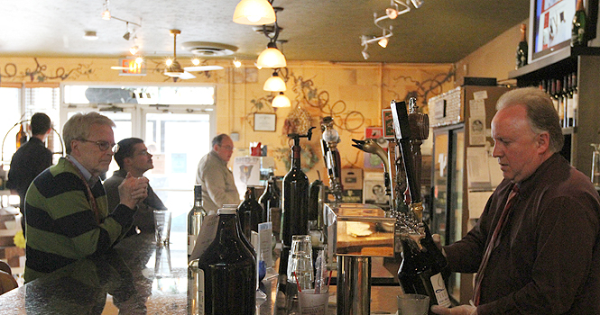 Owner Robert Morson fills a growler for a customer behind the bar of Riverside Wine, April 13. Photo by Chelsae Ketchum.