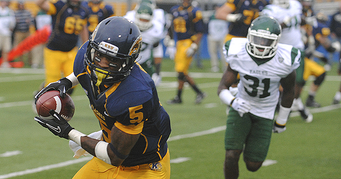 Junior wide receiver Tyshon Goode ran in the extra point for the Flashes after they scored a touchdown that put them in lead during their game against the Eastern Michigan Eagles on Saturday, Nov. 19. The Flahses took their fourth consecutive victory with a final. Photo by Jenna Watson.