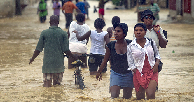 Residents of Cite Soleil, Haiti, walk through flooding water that has taken over Route Neuf overnight, as Tropical Storm Isaac brought heavy rains and wind to the area, Saturday, Aug. 25, 2012. Photo courtesy of MCT Campus.