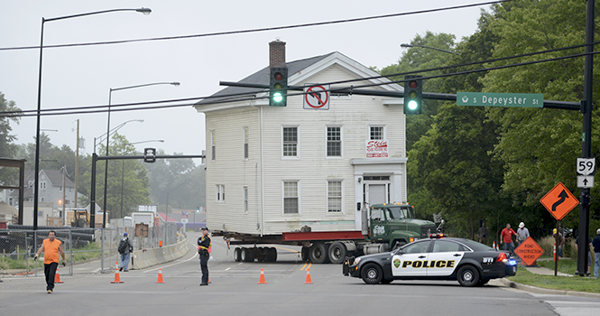 The Stein Movers company moves the Wells Sherman house down Haymaker Parkway on the morning of August 11. The house is now sitting at the west end of College Ave. while construction on the Esplanande extension is underway. Photo by Matt Hafley