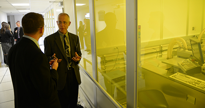 Timothy Langer from Parker Hannifin Corporation and Joe Klinehammer from GenVac Aerospace talk outside of a class-1000 clean room in the Liquid Crystal Institute building after a tour of the facility on Thursday. The tour of LCI concluded the two day Photo by MATT HAFLEY.