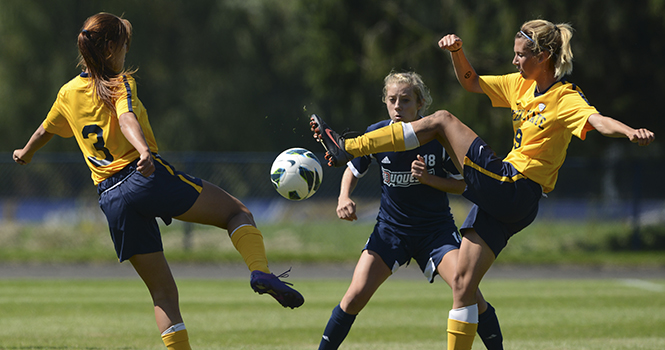 Sophomore forward Stephanie Haugh and senior forward Megan Repas both attempt to steal the ball from midfielder Caroline Lacy during Sunday's game. The Flashes fell to the Dukes 2-1. Photo by MATT HAFLEY.