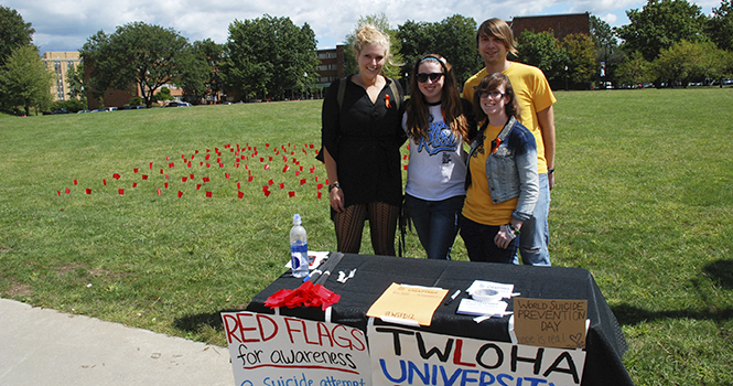 From left to right, Olivia Wells junior Fashion Merchandise major, Jessica Corson senior Marketing major, Lillian Scott sophomore Fashion Merchandise major and Dan Mosora Computer Science graduate student members of To Write Love On Her Arms University Chapters placed red flags in Manchester Field for World Suicide Prevention Day September 10. Photo by Grace Jelinek.