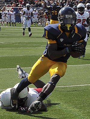 Senior running back/wide reciever Dri Archer evades a Ball State defender to cross the goal line and help lead the Golden Flashes to a 45-43 victory at Saturdays game at Dix Stadium. Archer had a stellar game, running for 104 yards and scoring two rushing touchdowns and one 99-yard kickoff return touchdown for the Flashes. Photo by Jessica Denton.