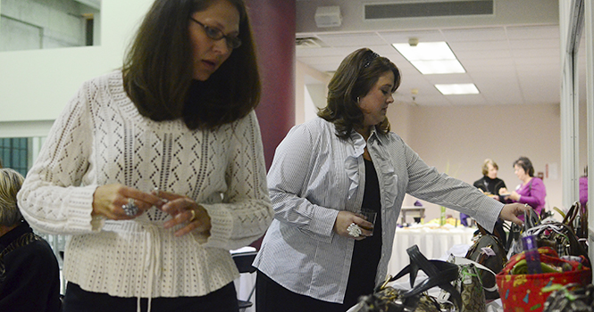 Heather Miller and Rachel Lancaster look at the purses at the Hope in a Handbag fundraiser, which raises money for Safer Futures, at Rockwell Hall on Oct. 13. Miller and Lancaster used to work with Safer Futures and came to support it. Photo by: Nancy Urchak
