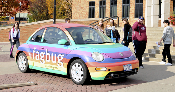 Students stop to take a look at the FagBug in front of the M.A.C. Center on the Kent State campus on Tuesday afternoon. The owner, Erin Davies, was inspired after her own VW Beetle was vandalized in Albany, NY, and she drove the car around for a year and made a documentary about her experience and to help raise awareness about hate crimes and homophobia. Photo by Jessica Denton