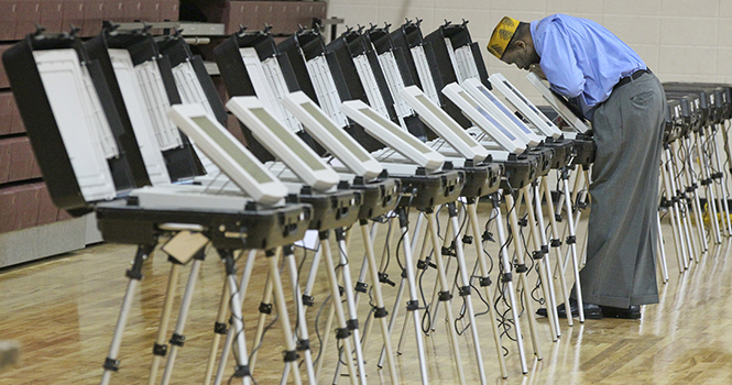 Poll Manager Melvin Davis Jr. unlocks the voting machines Tuesday, November 6, 2012, at Grady High School in Atlanta, Georgia.. Photo by John Spink/Atlanta Journal-Constitution/MCT.