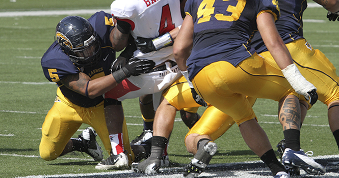 Ball States Horactio Banks is tackled by junior defensive lineman Roosevelt Nix (#5) at Dix Stadium on Sept. 29. Nix was named MAC defensive player of the week on Nov. 5, 2012. Photo by Brian Smith.