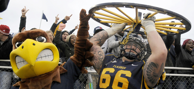 Kent State offensive lineman Brian Winters holds up the Wagon Wheel with Flash, after the Kent State football team won the PNC Wagon Wheel Challenge against Akron on Nov. 3. The Flashes won the game against the Zips 35-24. Photo by Hannah Potes.