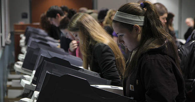 Students cast their vote for the presedential election while others wait in line Tuesday, Nov. 6 inside the Student Recreation and Wellness Center. Some students waited as long as an hour before casting their vote. Photo by Shane Flanigan