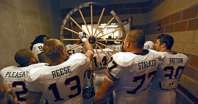 The Flashes carry the Wagon Wheel back into the visitors locker room at Infocision Stadium in Akron after beating the Zips 35-3 on Saturday, Nov. 12. Photo by MATT HAFLEY.