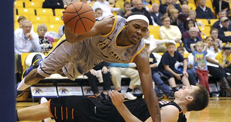 Kent State senior forward Chris Evans (5) is blocked by Princeton University junior guard T.J. Bray and falls to the floor on Saturday, Dec. 1. The Princeton University Tigers beat the Golden Flashes 62-50. Photo by Kristin Bauer.