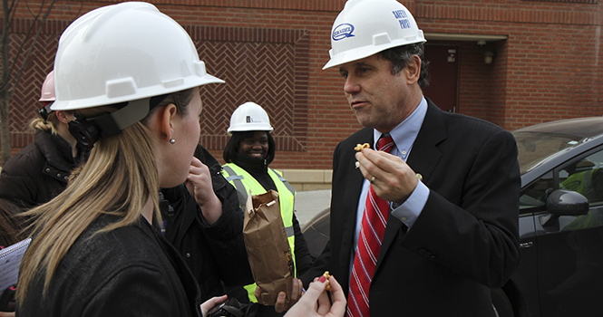 Senator Sherrod Brown shares popcorn with reporters during his tour of the downtown Kent renovation and construction projects Wednesday, Jan.16. Senator Brown also announced an extension to a tax bill which helped create jobs and fund the renovation effort in Kent. Photo by Shane Flanigan.