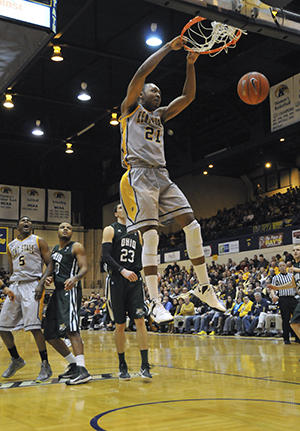 Kent State Mens Basketball forward Khaliq Spicer hangs from the rim aftering dunking during Saturday nights game against Ohio University in the MAC Center. The Golden Flashes lost to the Bobcats, 69-69, in an intense last-second game.. Photo by Jessica Denton.