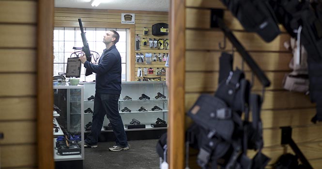 Diamond resident Adam Nowak browses at Sporting Defense LLC on Saturday, Jan. 12. Larry John opened the gun shop in Brimfield, just outside of Kent, in August of 2012. Lately, John says sales have been higher than ever, especially since the gun control debate resulting from the recent school shootings in Connecticut. Photo by Jenna Watson.