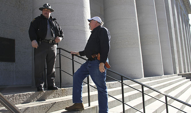 Phil Ouellette, 54, of Westerville speaks with an Ohio State Highway Patrol officer on the steps of the Ohio Statehouse in downtown Columbus during the Guns Across America rally Saturday, Jan.19. Ouellette, a gun owner himself, came out to support his 2nd amendment rights. Until something bad happens to you or someone you know, it’s hard to take [gun rights] that seriously, he said. Photo by Shane Flanigan.