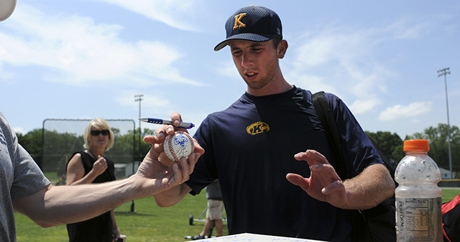 Kent State University’s infielder, Nick Hamilton, signs a baseball and a home plate from Glenn Peterson. Peterson, from Vermillion, Ohio, along with his son, drove out to Omaha, Neb. to watch his alma mater compete in the College World Series. Peterson is a 84 graduate of the university and brought his son with him to Omaha. “It’s one of those father and son things to do on Father’s Day.” Peterson’s son, Mitchell plays first base and outfield on the Vermilion High School baseball team. Photo by Philip Botta.