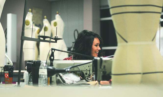 Jade Synder, senior fashion design major, laughs with her friend while lining a top in Rockwell Hall on Feb. 19, well after midnight. Photo by Jacob Byk.
