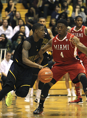 Sophomore guard Kris Brewer dribbles the ball on Feb. 13. Kent State won against Miami 87-70. Photo by Chloe Hackathorn.