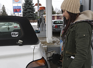 Senior Ilenia Teresa pumps ten dollars of gas into her car before commuting home for lunch, February 20. Photo by Chelsae Ketchum.