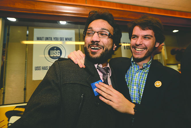 Phi Delta Theta president Ben Putano (right) congratulates Amish Patel (left) as the newly elected Executive Director of Undergraduate Student Government after receiving results of the election. Patel ran against Erik Clarke for the position. Photo by Matt Unger.