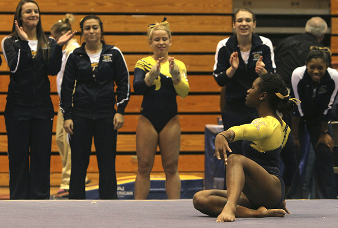 The+Kent+State+gymnastics+team+cheers+on+sophomore+Amiah+Mims+at+the+end+of+her+floor+routine+during+a+home+victory+Jan.+25+at+the+MACC+over+Western+Michigan+and+George+Washington%2C+194.675+to+194.125+to+193.875+respectively.+Photo+by+Shane+Flanigan.