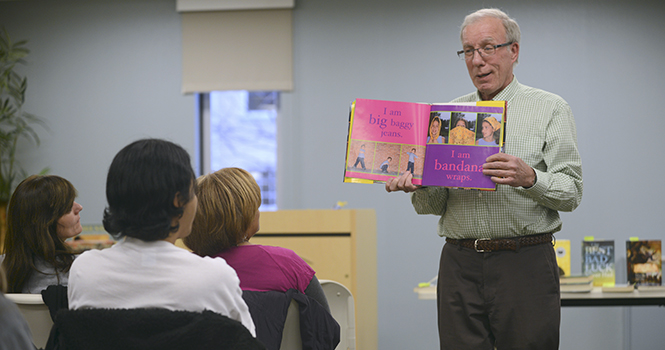 John Jarvey, a retired teacher, reads I Am America by Charles R. Smith to students and teachers during a discussion on global literature in White Hall on April 11. Photo by Melanie Nesteruk.