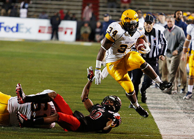 Sophomore running back Trayion Durham hurdles over an Arkansas State player during the 2013 GoDaddy.Com Bowl in Mobile Alabama, on January 6. Kent State was unable to beat Arkansas State losing the bowl game 13-17. Photo by Coty Giannelli