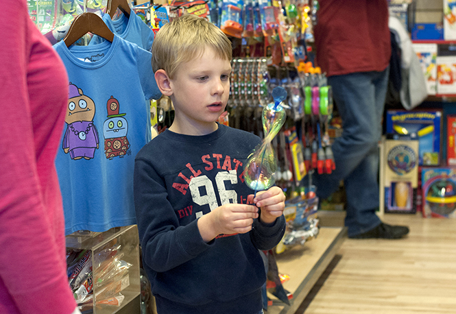 Nick Steger, 6, of Rootstown, examines a toy closely while exploring Off the Wagon toy shop Tuesday, Sept. 17. Photo by Brianna Neal.