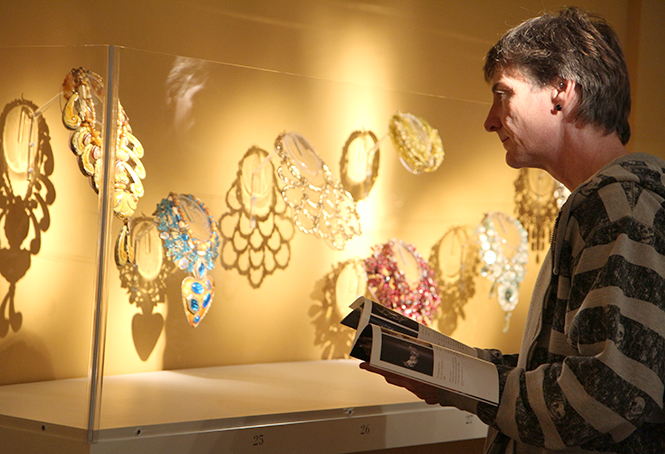 Jeffrey Bednarcik views jewelry created by Arthur Koby for the exhibition “The Creative Eye” at the Kent State University Museum on Thursday, Oct. 24, 2013. The exhibition will be open from Oct, 25, 2013, to Oct. 5, 2014. Arthur Koby was described by Vogue magazine as “one of the masters of collage.” Photo by Yolanda Li.