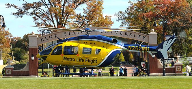 Spectators gather to watch as the Metro Life Flight helicopter lands on the Kent State esplanade on Tuesday, Oct. 22, 2013. The helicopter visited to promote the new graduate nursing program at Kent State that now offers clinical experiences onboard the Metro Life Flight for students in the acute care nurse practitioner concentration. Photo by Rachael Le Goubin.