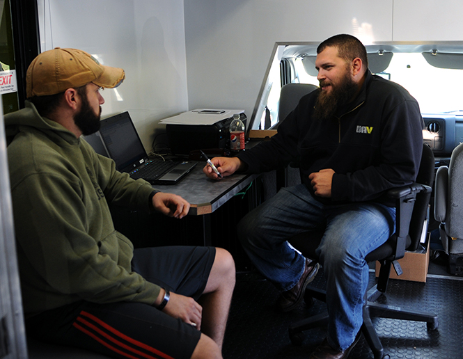 Matt Deibel (left) and Steven Strodtbeck (right) sit at the office the DAV has established in a mobile unit on Tuesday Oct. 22, 2013. The DAV mobile unit travels around Ohio helping veterans file disability claims for injuries obtained while in the service. Currently the mobile unit has been traveling to Ohio college campuses assisting veterans serving post-9/11 with any questions they might have regarding benefits they are entitled to or how to file disability claims. Photo by Rachael Le Goubin.