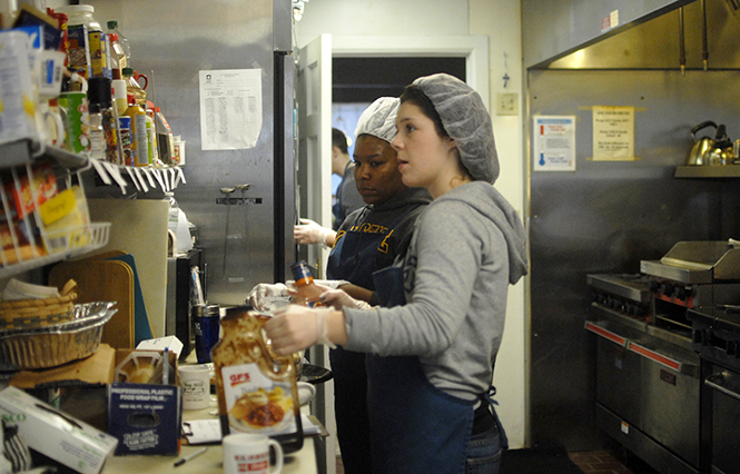 Senior nursing major Kaleigh Conner and graduate school counseling major Jasmine Finch clean up after serving food at the Kent Social Services on Jan. 21, 2013. Social-service centers worry that the cuts in the Supplemental Nutritional Assistance Program will cause large increase in demand for their resources. Photo by Jacob Byk.