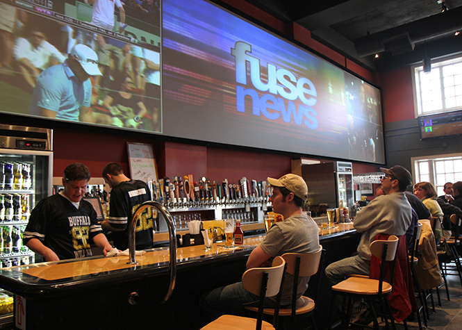 Patrons at Buffalo Wild Wings in downtown Kent watch the new locations big screen televisions above the bar on Saturday, April 6. Photo by Shane Flanigan.