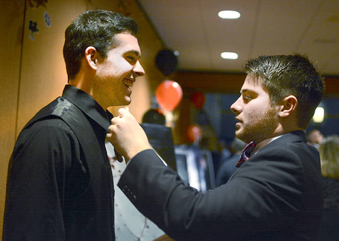 Jason Kilbane, sophomore electronic media production major, gets his bow tie fixed by his friend and fellow fraternity member, architecture senior Andrew Burson, at the opening of Hell at Heathridge on Thursday, Dec. 5, 2013. Kilbane was a part of the production for the film. Photo by Jacob Byk.
